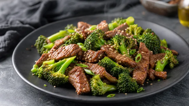 Keto beef and broccoli from the wok with sesame seeds plated on a dark dish