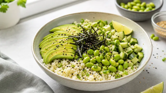 Keto avocado edamame poke bowl with sliced avocado, edamame, diced cucumber and sesame seeds over cauliflower rice