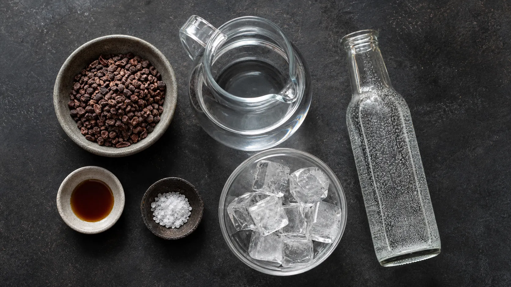 Ingredients for keto cold brew cocoa tonic with cocoa nibs, water, vanilla, salt, tonic water and ice
