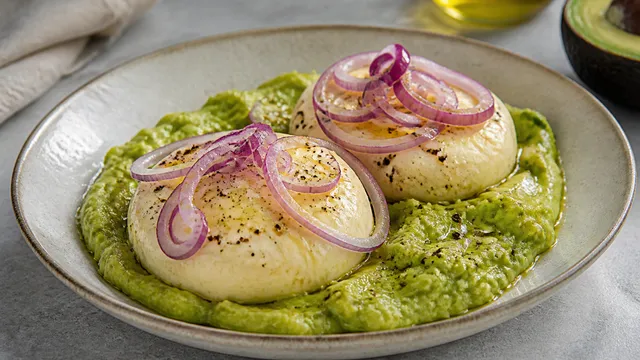 Handkase on avocado cream with red onions, lemon juice and olive oil