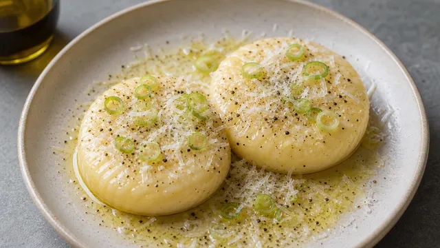 Keto handkase with white truffle oil, Parmesan, spring onions and black pepper on a plate
