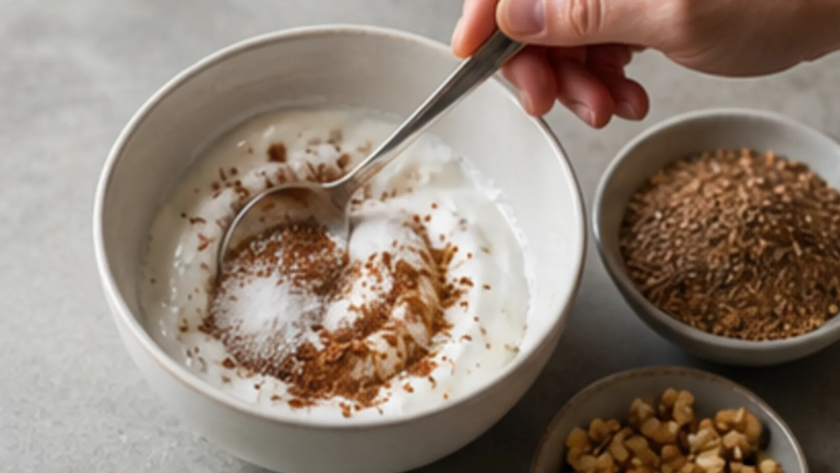 Coconut yogurt being stirred with cinnamon and erythritol for a keto breakfast bowl