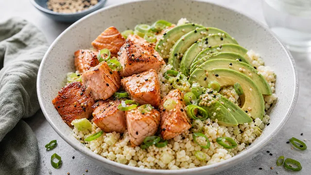 Keto salmon bowl with pan-seared salmon, cauliflower rice, avocado and sesame seeds
