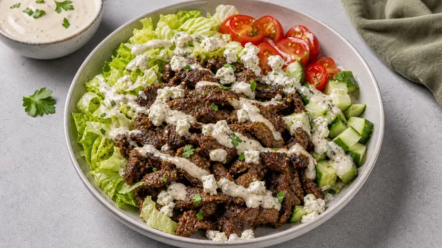 Keto lamb shawarma bowl with salad, cucumber, tomatoes, feta and tahini garlic sauce