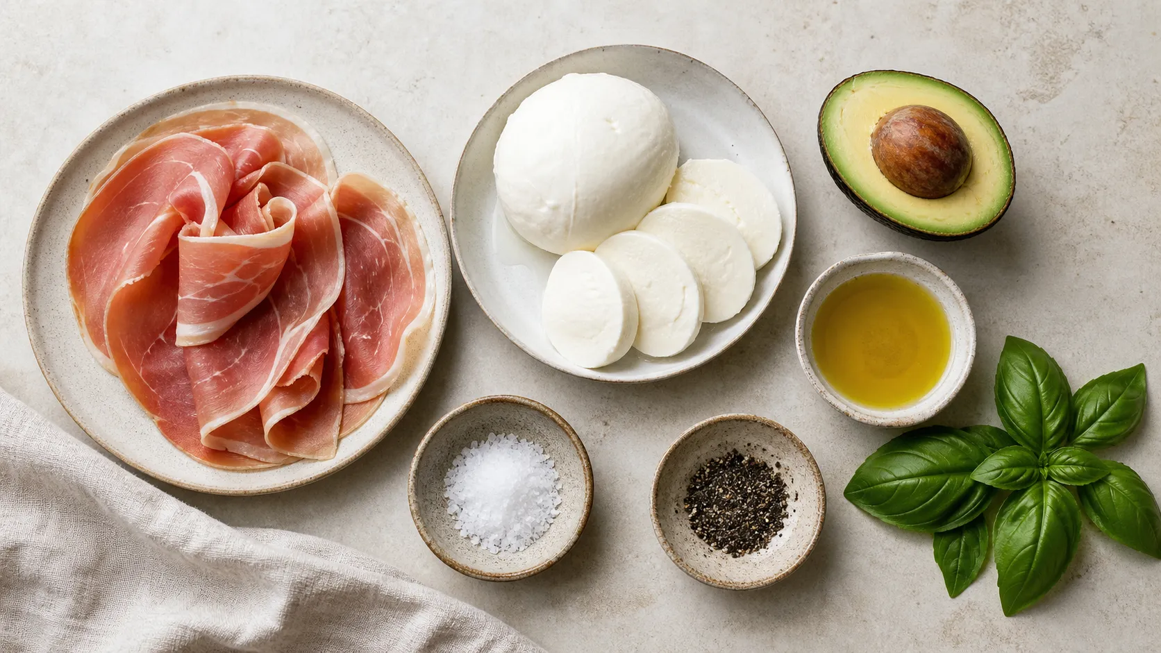 Ingredients for Keto Breakfast Plate with Prosciutto, Mozzarella and Avocado: 60 g prosciutto, 100 g mozzarella, 80 g avocado (approx. ½ fruit), 15 ml olive oil (approx. 10 ml), 3–4 fresh basil leaves, Salt