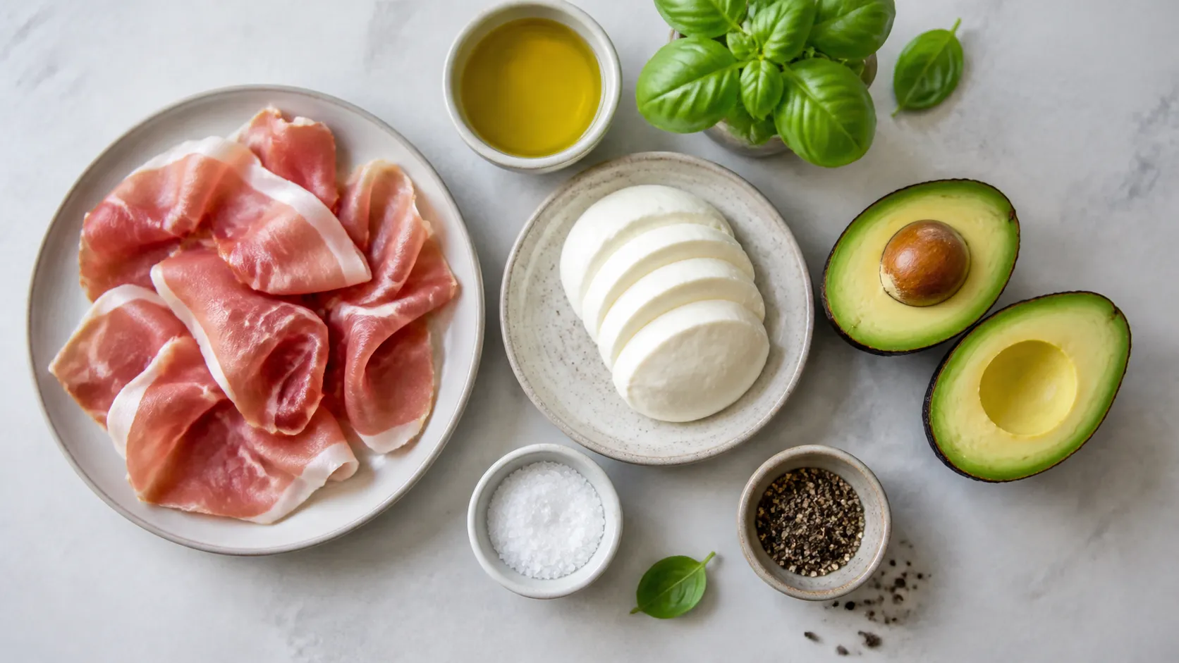Ingredients for the keto breakfast plate: prosciutto, mozzarella, avocado, olive oil