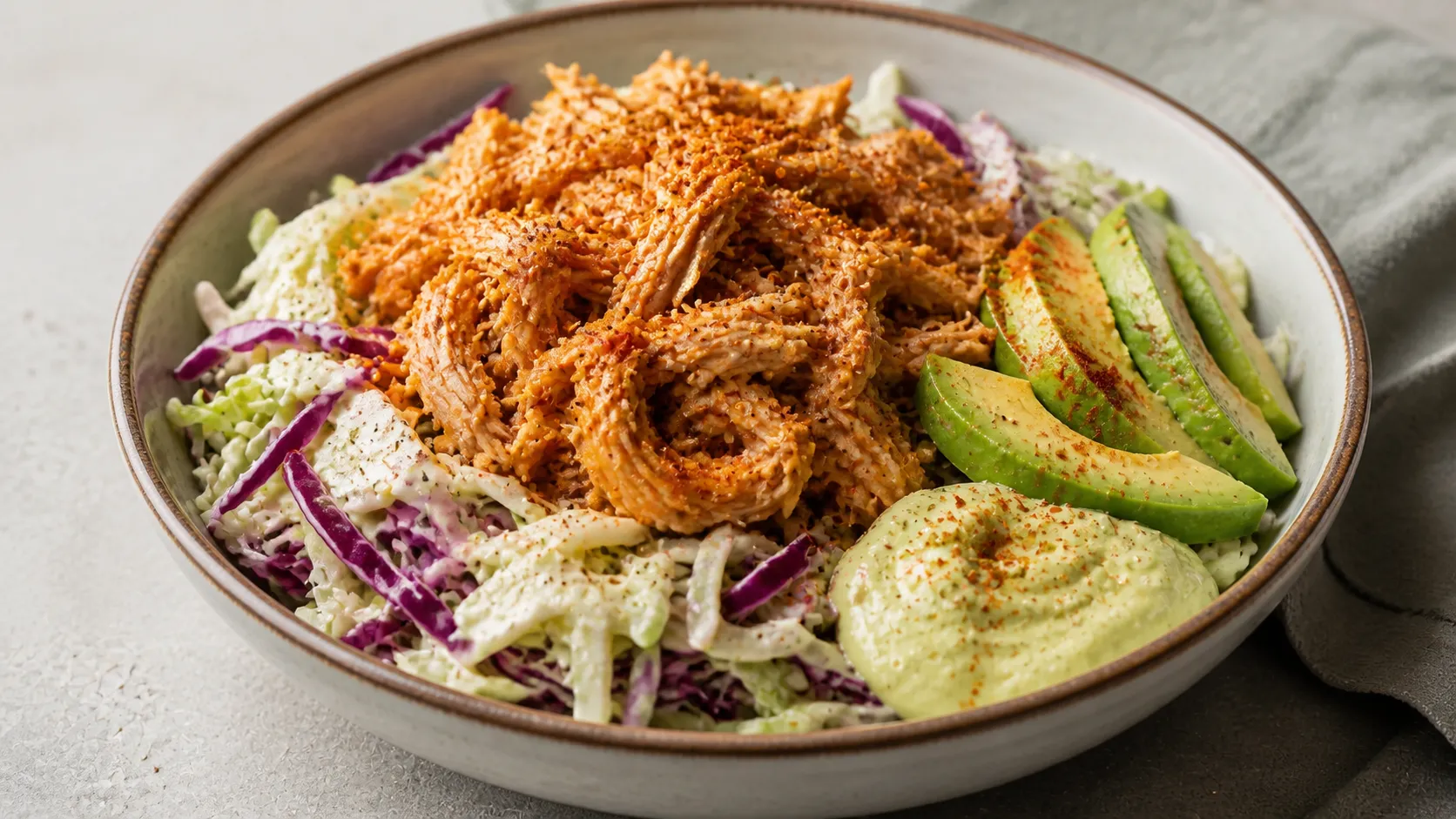 Keto pulled chicken bowl with colorful coleslaw, avocado and smoked paprika in a bowl