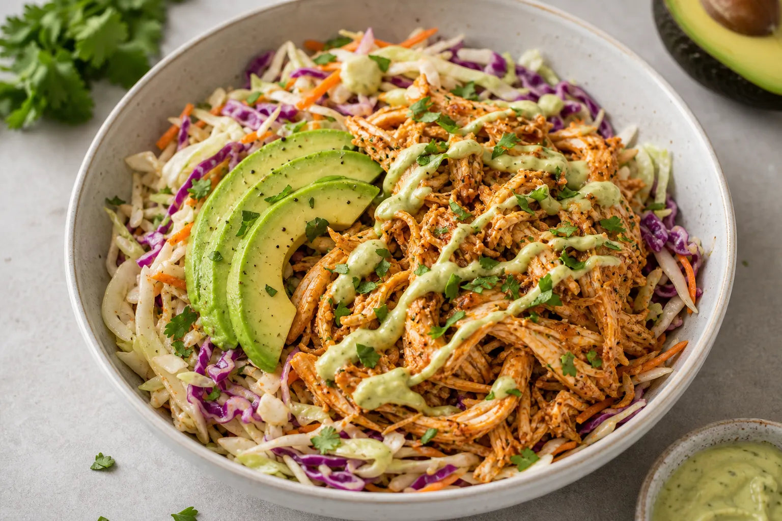Keto pulled chicken bowl with colorful coleslaw, avocado and smoked paprika in a bowl