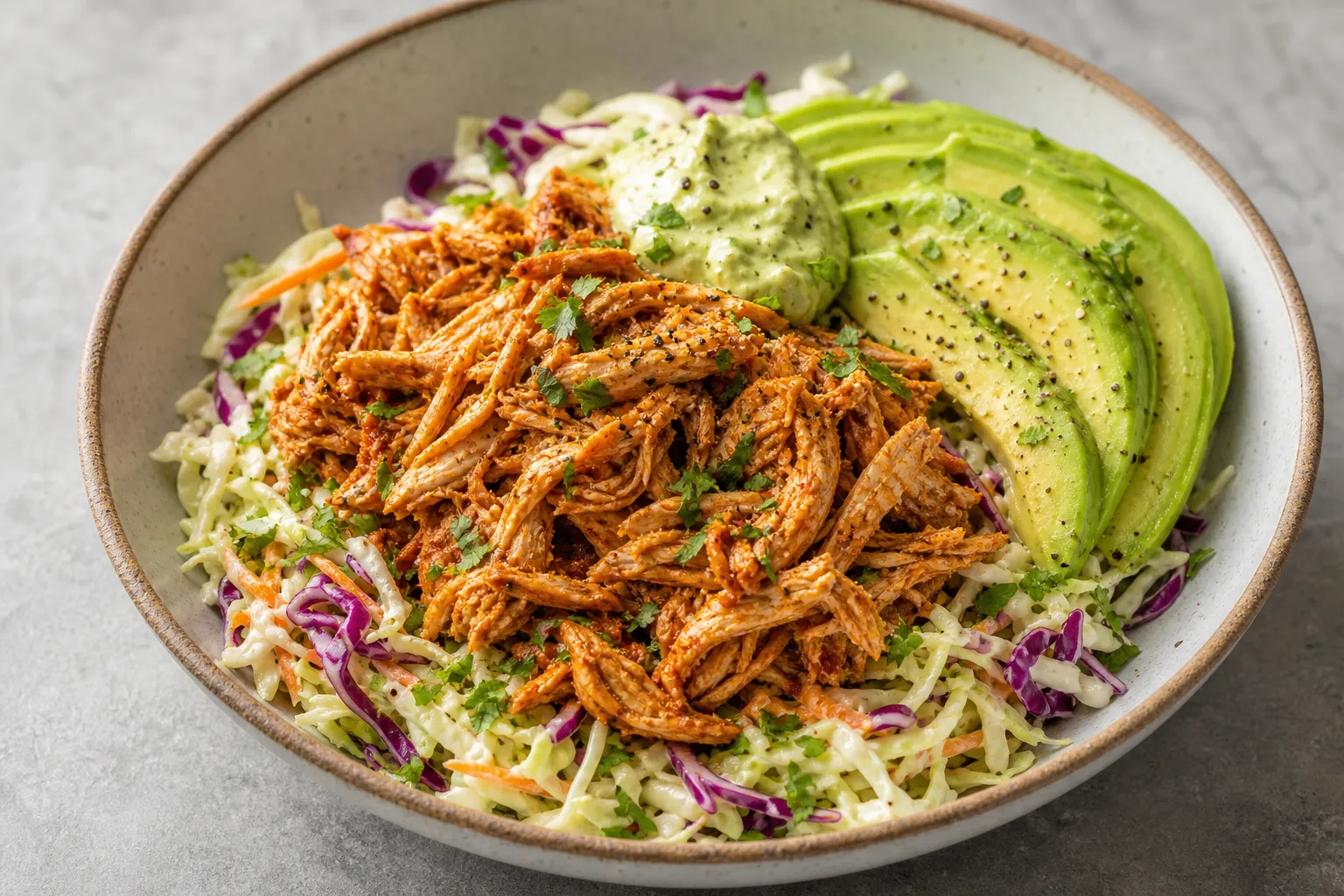 Finished keto pulled chicken bowl with coleslaw and avocado plated