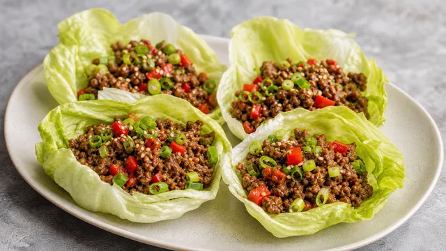 Keto beef lettuce wraps with seasoned ground beef, bell pepper and sesame served in lettuce leaves