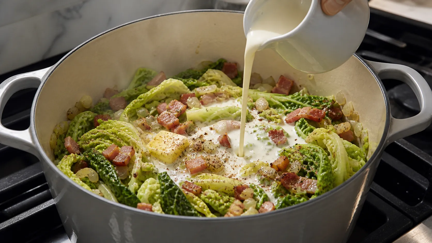Cream is poured into savoy cabbage with bacon, shallot and garlic in a pot