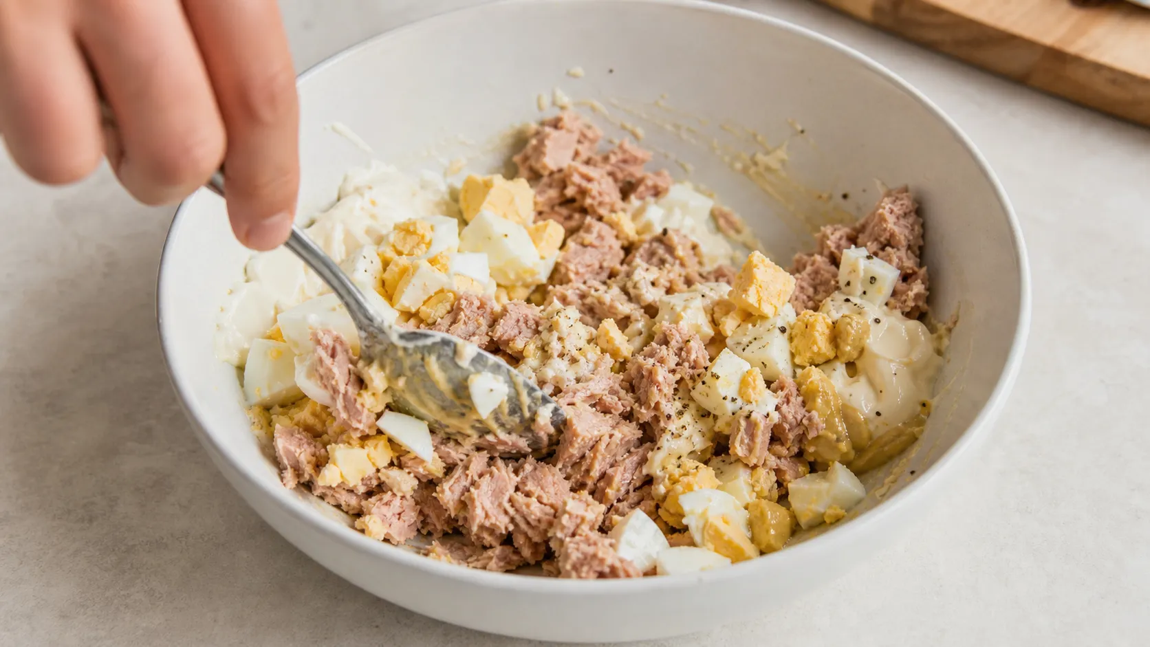 Preparation step for Keto Tuna Egg Salad – Protein Breakfast in 3 Minutes: Peel the hard-boiled egg and chop it into rough pieces.